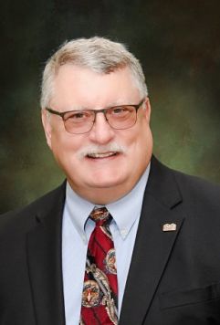 Pictured is R.D. Williams, Chief Executive Officer. He is in a suit smiling.