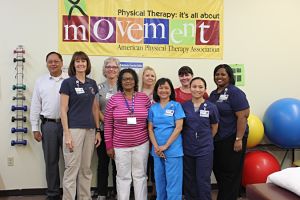 This is some of the rehabilitation center staff (male and female) standing up and smiling at the camera